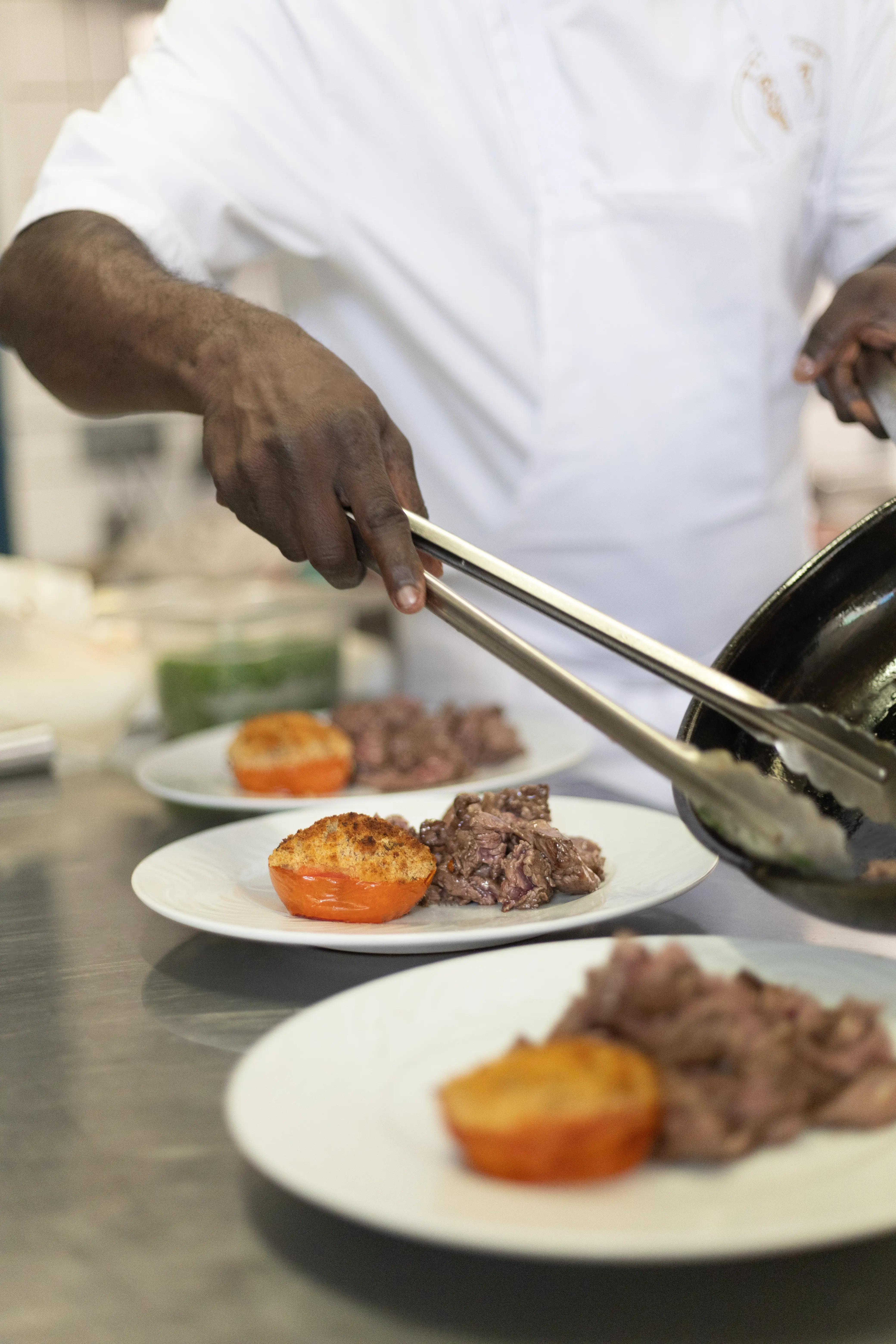 Le chef dresse une assiette à la pince