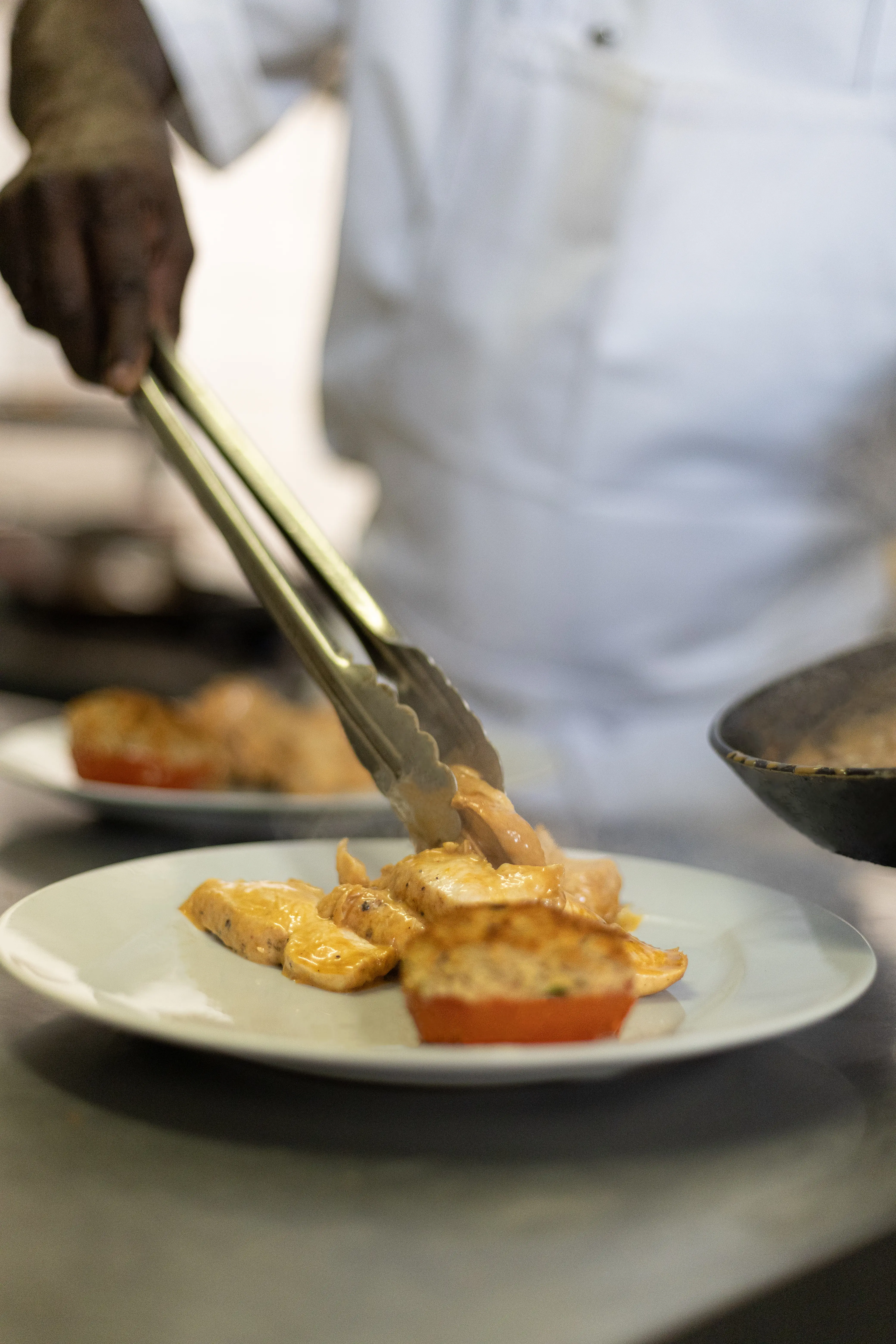 Le chef dresse un plat à la pince